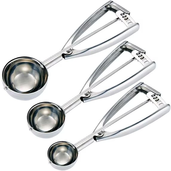Three metal ice cream scoops of different sizes, practical kitchen favorites, are arranged diagonally on white.