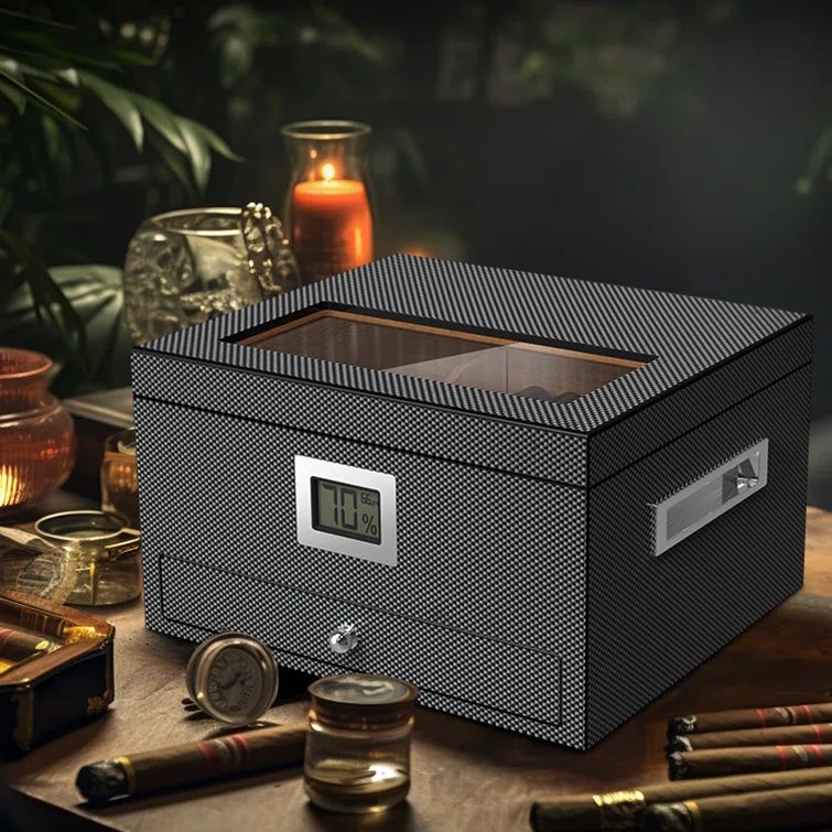 Carbon-fiber humidor with digital hygrometer—one of the best gifts for a man—on a wooden table with cigars and candles.