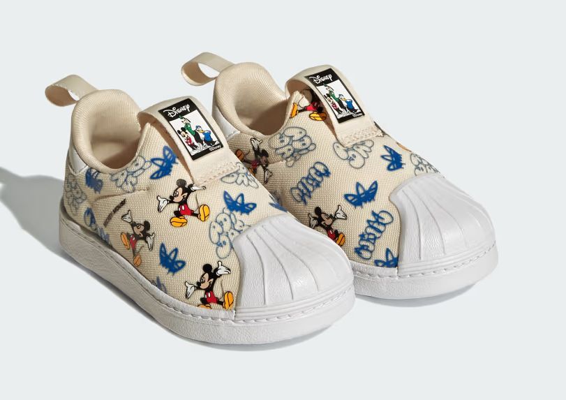 Beige kids’ adidas toddler shoes with blue and Mickey Mouse prints, white soles, and Disney logo on the tongue.