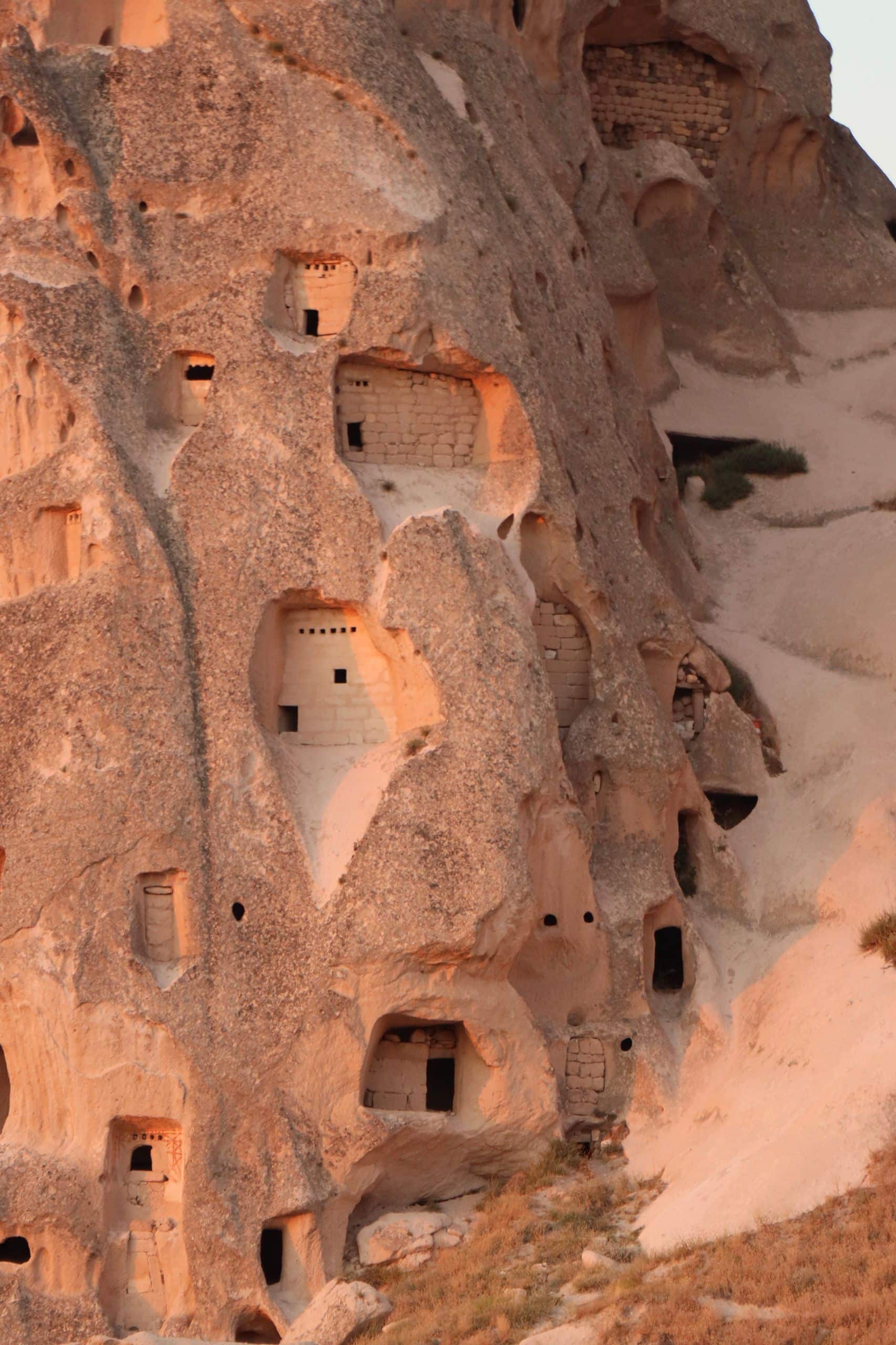 Explore the historic sandstone cave dwellings carved into the cliffside, showcasing ancient architecture.