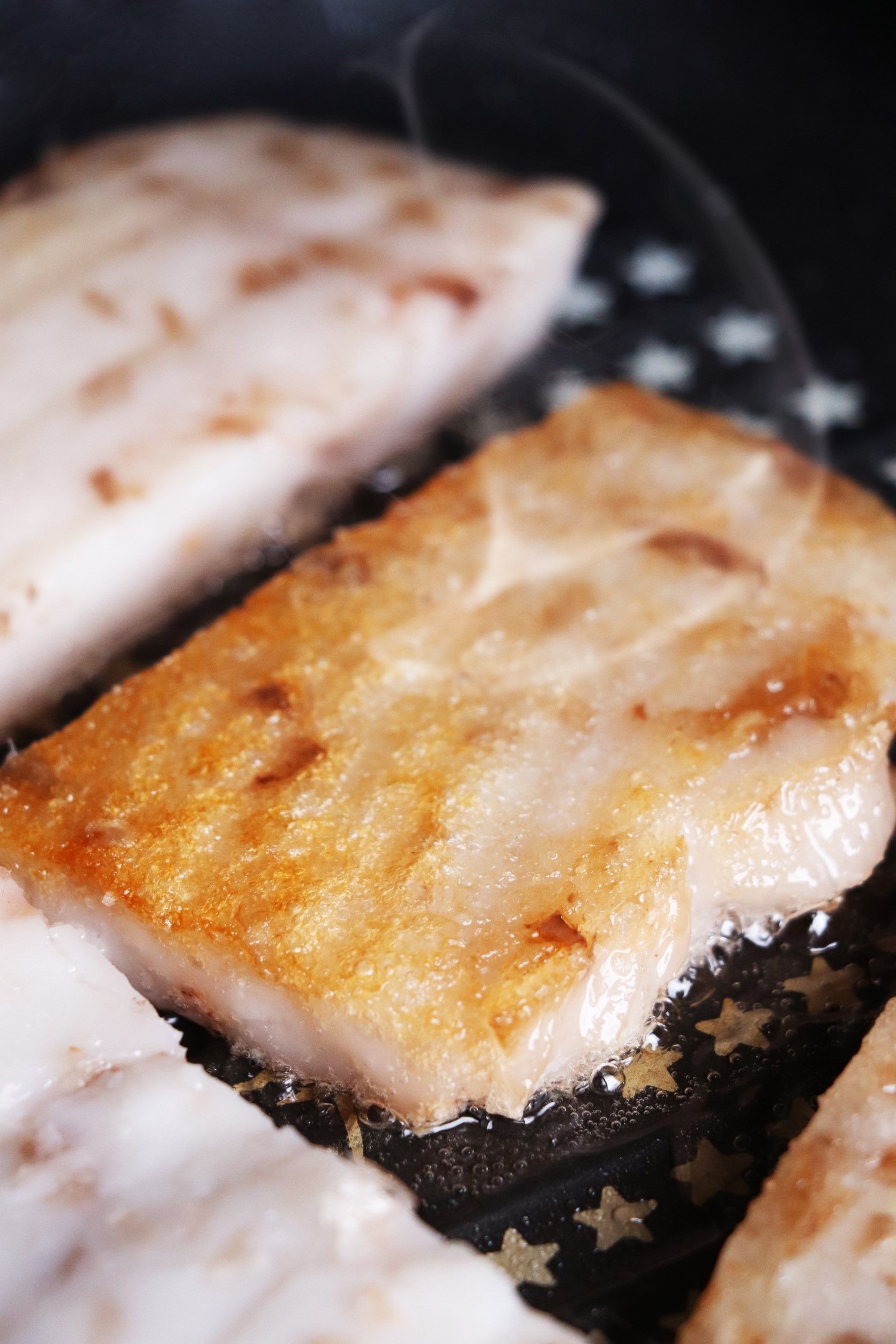 Sizzling golden-brown fish fillet frying in a pan