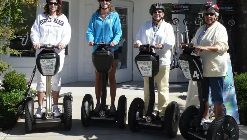 Four people enjoy one of the best things to do in Myrtle Beach—riding Segways together on a sunny day.